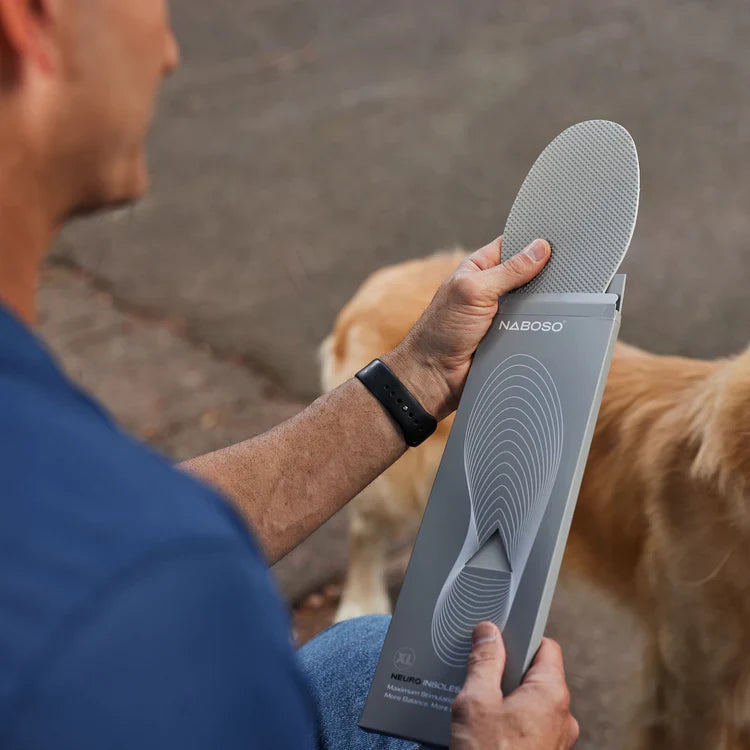 A man holding Naboso Neuro Insoles package and unpacking the insole from the box